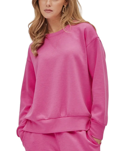 Person wearing a bright pink sweatshirt on a light gray background